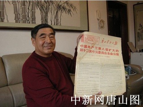 图为信宝忠展示刊登1968年11月2日党的八届十二中全会公报的报纸 