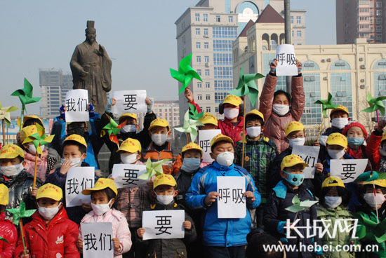 现场孩子们“抗击雾霾”的举动引起了市民共鸣。扈炜 摄